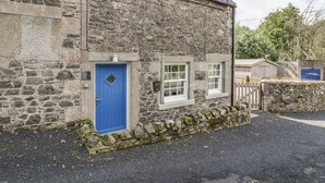 A stone building with a blue door and two windows. - Kirk Cottage (Kelso)