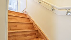 A wooden staircase with a handrail and a white wall. - Kirk Cottage (Kelso)