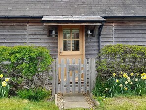 A wooden cottage with a wooden door and a small porch. - Bicton Lodge (Craven Arms)