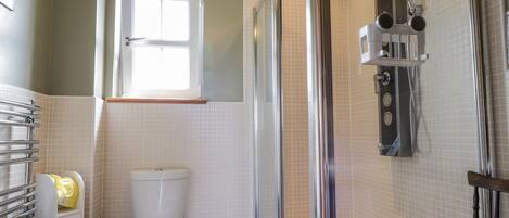 Ein Badezimmer mit Toilette, Dusche und Fenster.