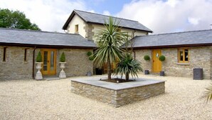 A stone building with two yellow doors and a central courtyard with a palm tree.