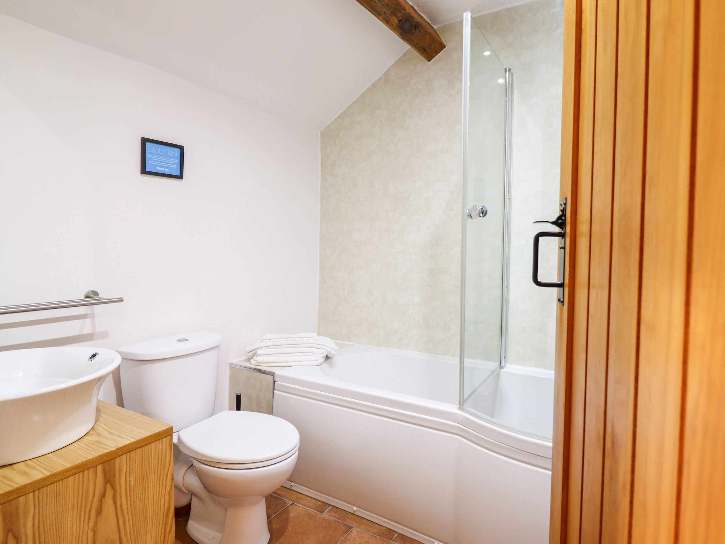 Een moderne badkamer met toilet, wastafel en bad.