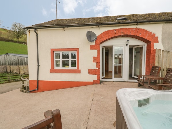 A building with a brick archway, a small window, and a hot tub.