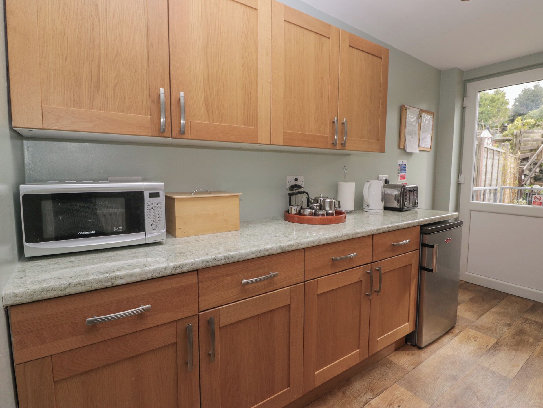 A kitchen with wooden cabinets, a microwave, a toaster, and a dishwasher.