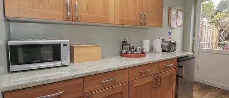 A kitchen with wooden cabinets, a microwave, a toaster, and a dishwasher.