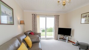 A living room with a sofa, a television, and a small elephant figurine. - Bryn Coch Bach (Dyffryn Ardudwy)