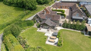 An aerial view of a large estate with multiple buildings, including a main house with a large patio and a conservatory. - The Turnip House (Craven Arms)
