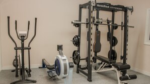 A home gym with a NordicTrack machine, a stationary bike, and a squat rack. - The Turnip House (Craven Arms)
