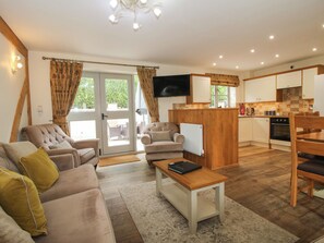 A living room with a sofa, a coffee table, and a television. - The Turnip House (Craven Arms)