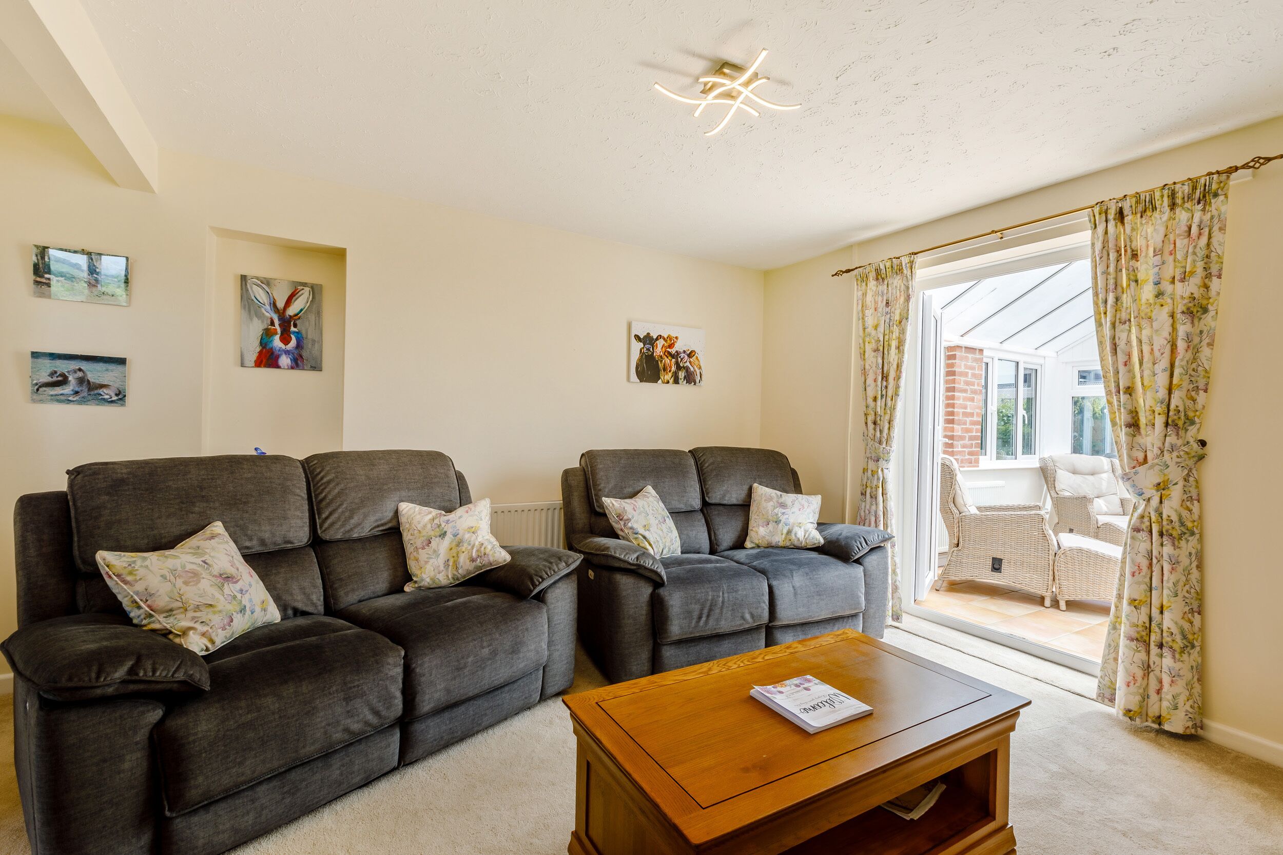 A living room with two grey sofas, a wooden coffee table, and a ceiling fan.