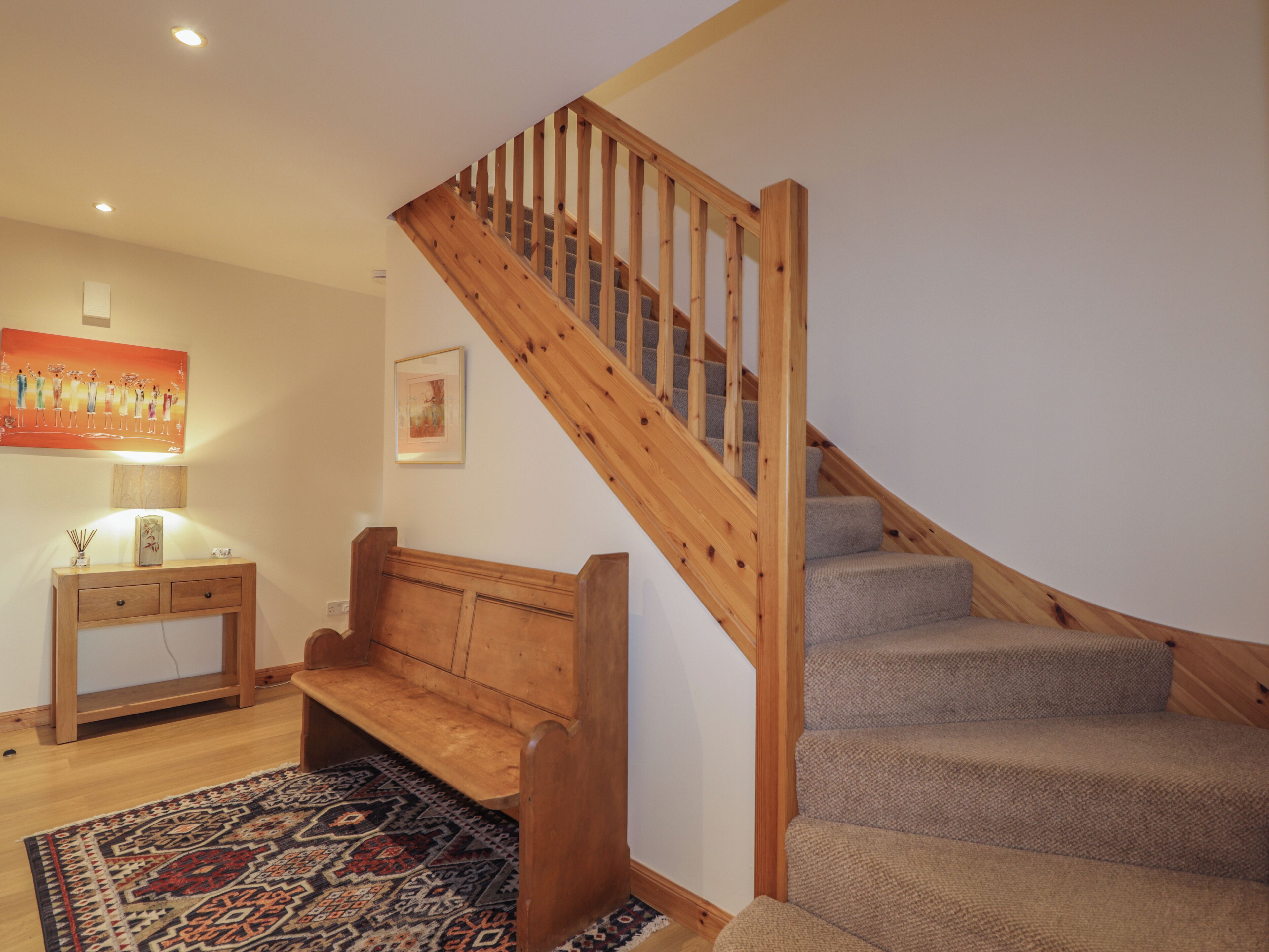 A staircase with wooden railings and carpeted steps.