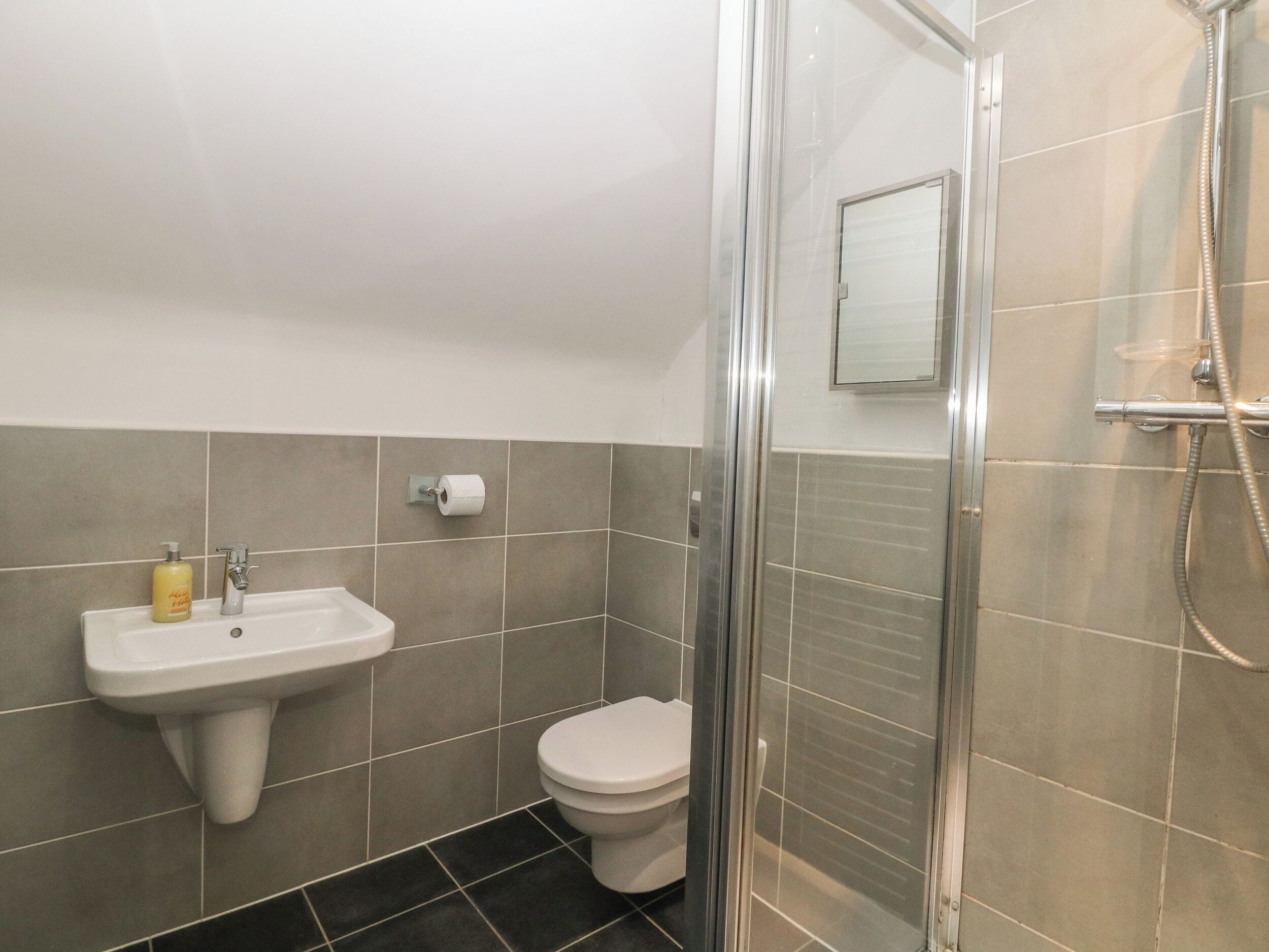 A bathroom with a sink, toilet, and shower.