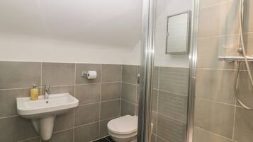 A bathroom with a sink, toilet, and shower.