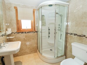 A bathroom with a glass-enclosed shower, a sink, and a toilet. - Cornfield (Northallerton)