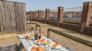 Una mesa de picnic al aire libre con comida y bebidas.