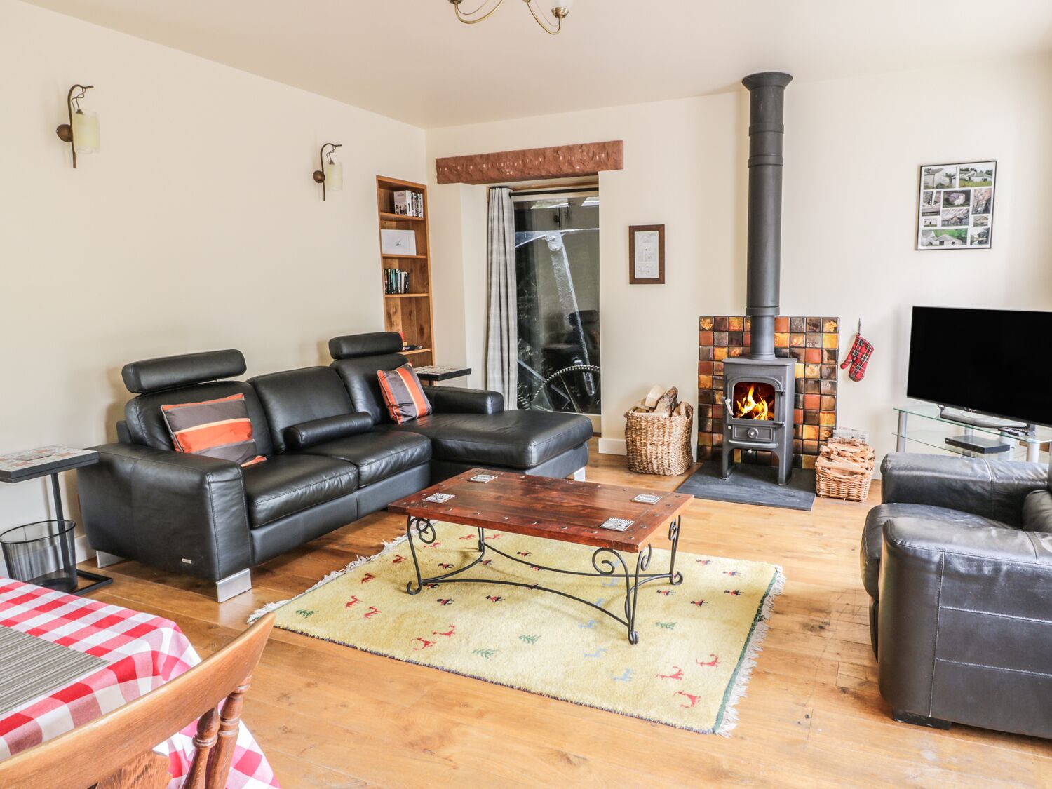 A cozy living room with a leather sofa, a wooden coffee table, and a fireplace.