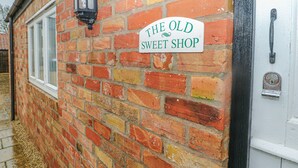 A brick wall with a sign that reads "The Old Sweet Shop". - Old Sweet Shop (Louth)