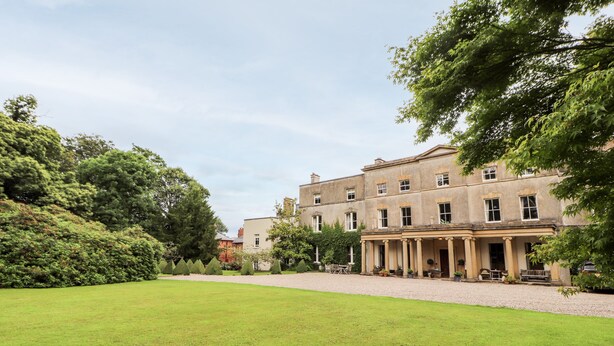 A large, historic building with a symmetrical facade, multiple windows, and a central entrance with columns. - Cook's Flat (Wrexham)