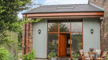 Guests can enjoy a charming entrance with a wooden door, glass panels, and a small porch area.