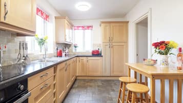 Cottage | Privékeuken | Een koelkast, een vaatwasser, kookgerei, borden en bestek