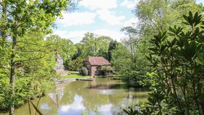 Une propriété située au bord de la rivière, comprenant une maison, un petit pont et un kiosque.
