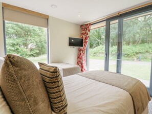 A bedroom with a large bed, a television, and a view of the outdoors. - Neddy Cut (Ulverston)