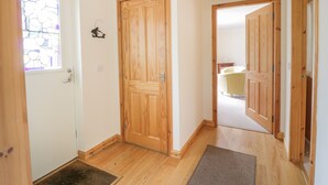 A hallway with wooden doors and a white wall. - Lon Cottage (Perth)