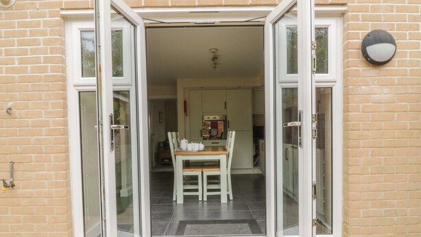 A residential entrance with a glass door leading to a dining area.