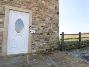 Stunning stone building with a charming entrance featuring a white door and an oval glass panel.