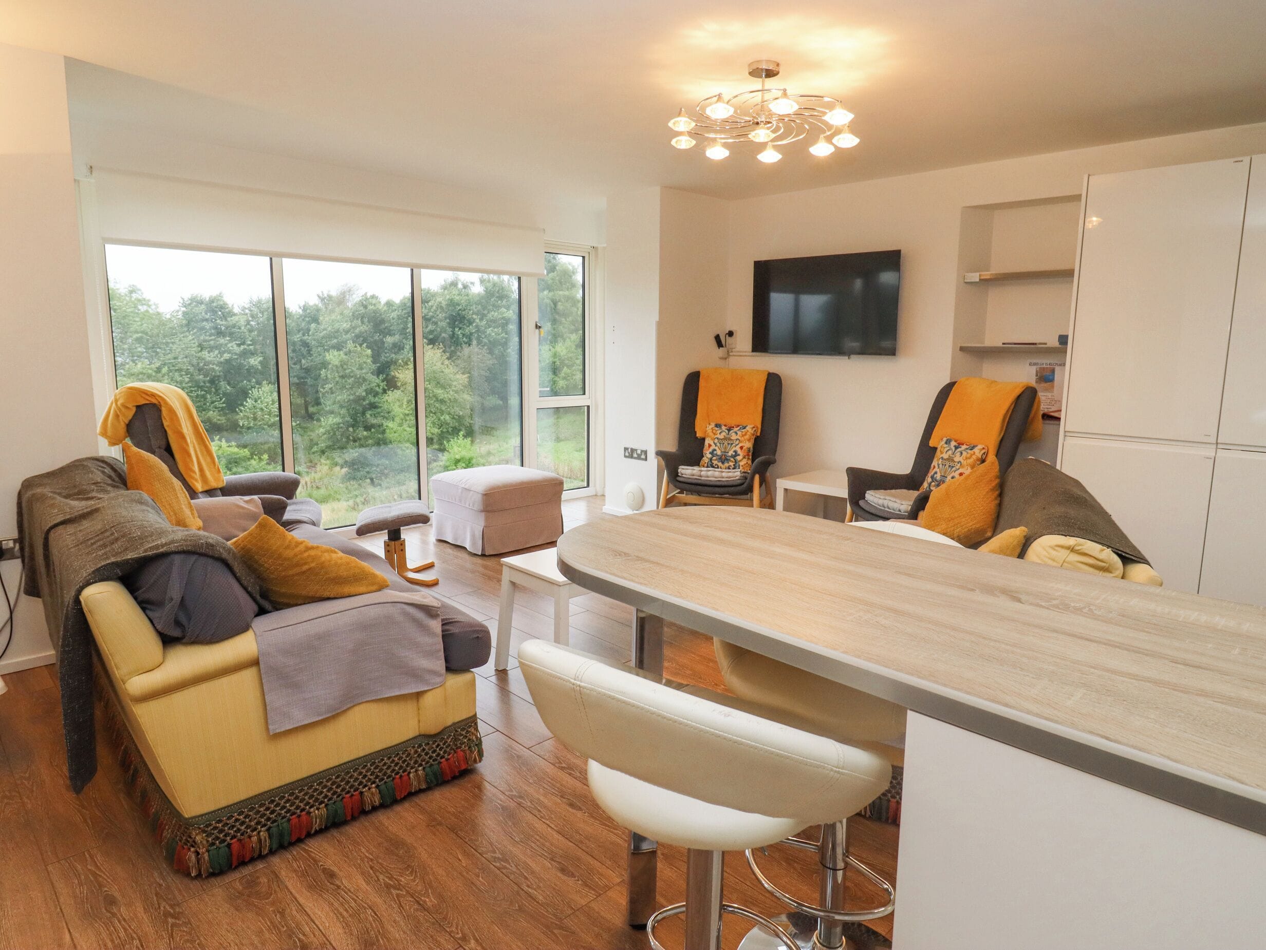 A modern living room with a sofa, ottoman, and bar area.