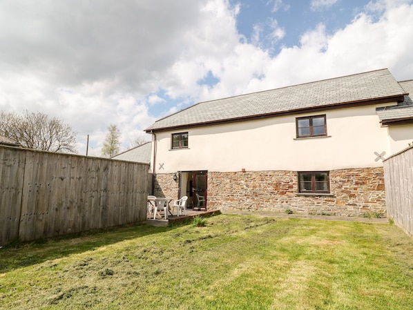 A two-story house with a stone facade and a tiled roof.