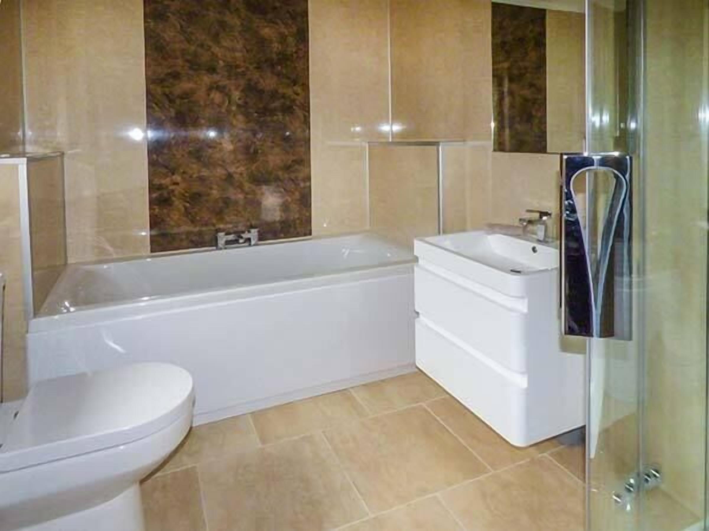 A modern bathroom with a bathtub, a sink, and a toilet.