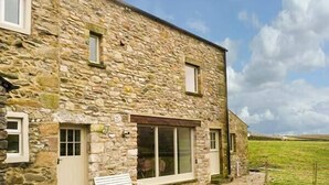 A stone building with a large window and a bench outside. - Dale House Farm Cottage (Carnforth)
