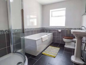 A bathroom with a glass shower enclosure, a bathtub, a toilet, and a sink. - Maerdy Cottage (Corwen)