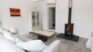 A living room with a sofa, a cabinet, a fireplace, and a painting on the wall.