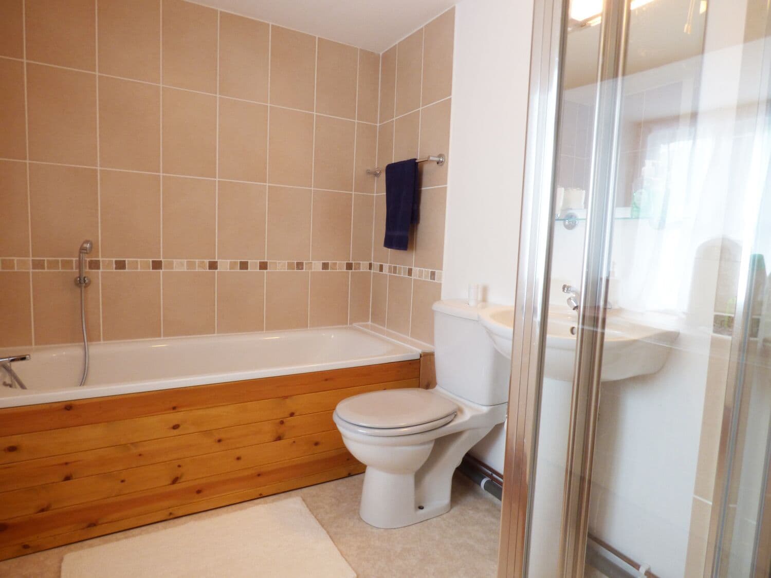 Une salle de bain équipée d’une baignoire, de toilettes et d’une douche à parois en verre.