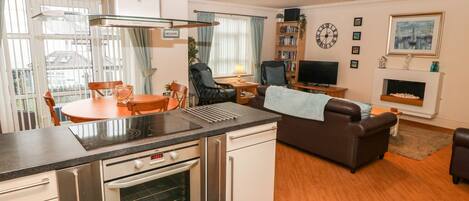 A modern kitchen with a built-in oven and a dining area with a table and chairs.