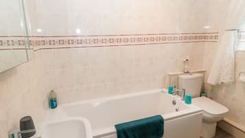 Une salle de bain avec une baignoire, des toilettes et un lavabo.