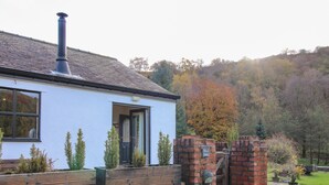 Una casa con chimenea, una puerta y un muro de ladrillos.