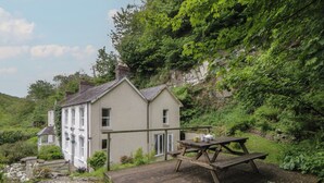 A house with a garden, a wooden deck, and a picnic table. - Teifi House (Cardigan)