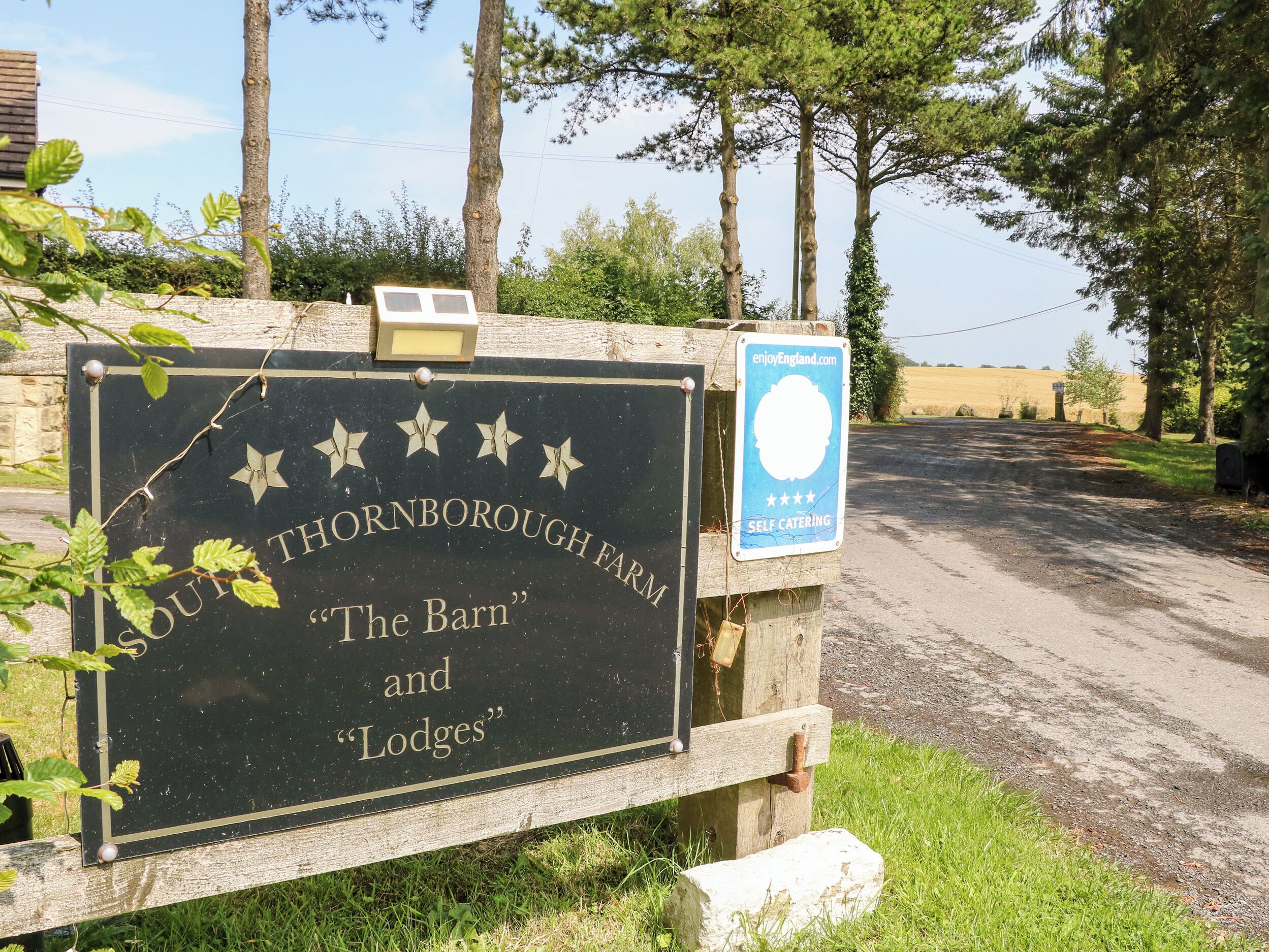 Señal para la granja South Thornborough, que incluye 'The Barn' y 'Lodges'.