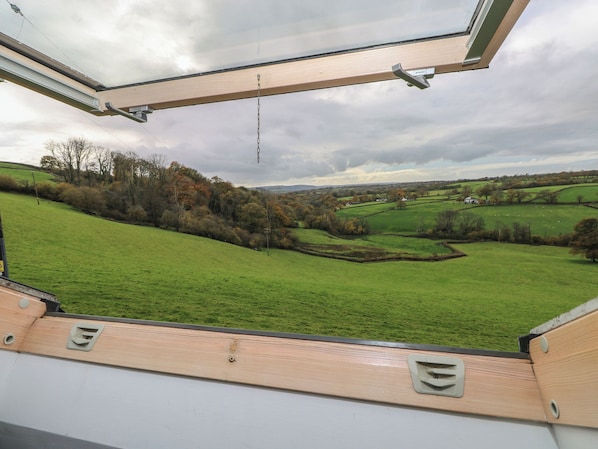 A view from a window with a wooden frame and a chain hanging from the ceiling. - Bwthyn-y-rhiw (Llandeilo)