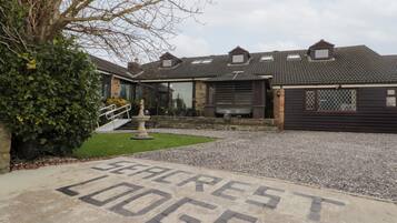A building labeled "Seaclrest Lodge" with a gravel driveway and a small garden area.