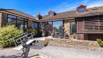 A house with a patio, outdoor seating, and a statue.