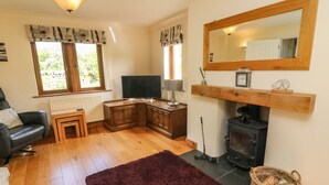 A cozy living room with a fireplace, a television, and a comfortable seating area.