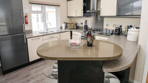 Una cocina moderna con una isla central, electrodomésticos de acero inoxidable y un ventanal que proporciona luz natural.