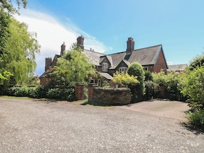 A large brick house with multiple chimneys, a gravel driveway, and lush greenery. - Just A Cottage, Newlands Farm (Alfreton)