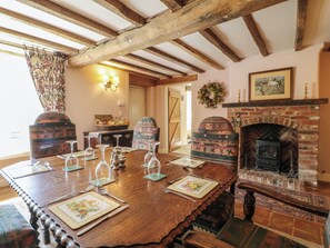 Ein Esszimmer mit Holztisch, gedeckt für vier Personen, Kamin und rustikaler Einrichtung.