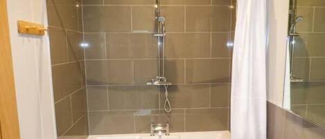 A modern bathroom with a walk-in shower, a standalone bathtub, and a vanity with a sink.
