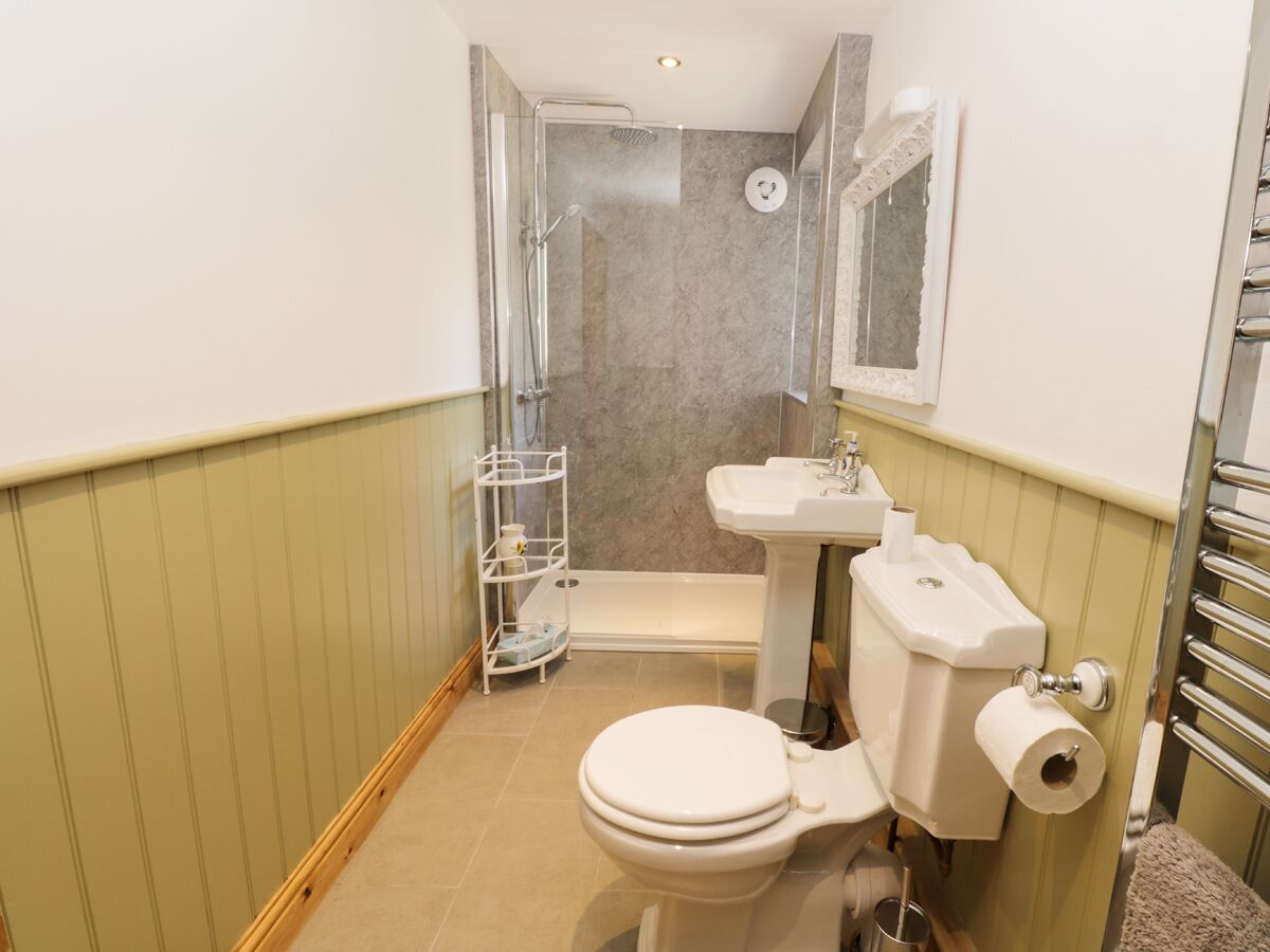 A compact bathroom with a toilet, sink, and shower.